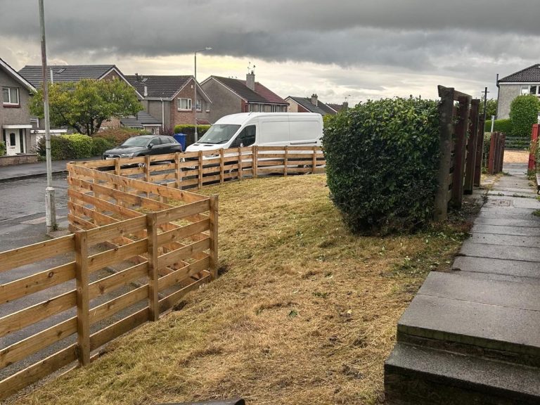 A suburban scene with wooden fencing, a grassy area, and a parked white van.